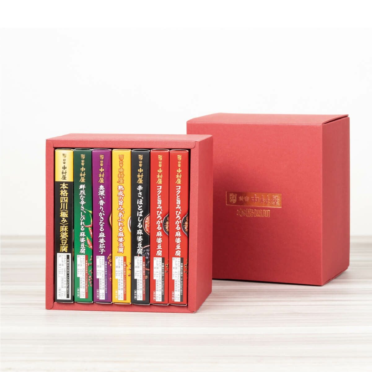 新宿中村屋 四川麻婆豆腐コンプリートBOX（赤）の蓋を開けた状態。麻婆豆腐や麻婆茄子などの中華ソースが詰め合わせられた内容が見える画像