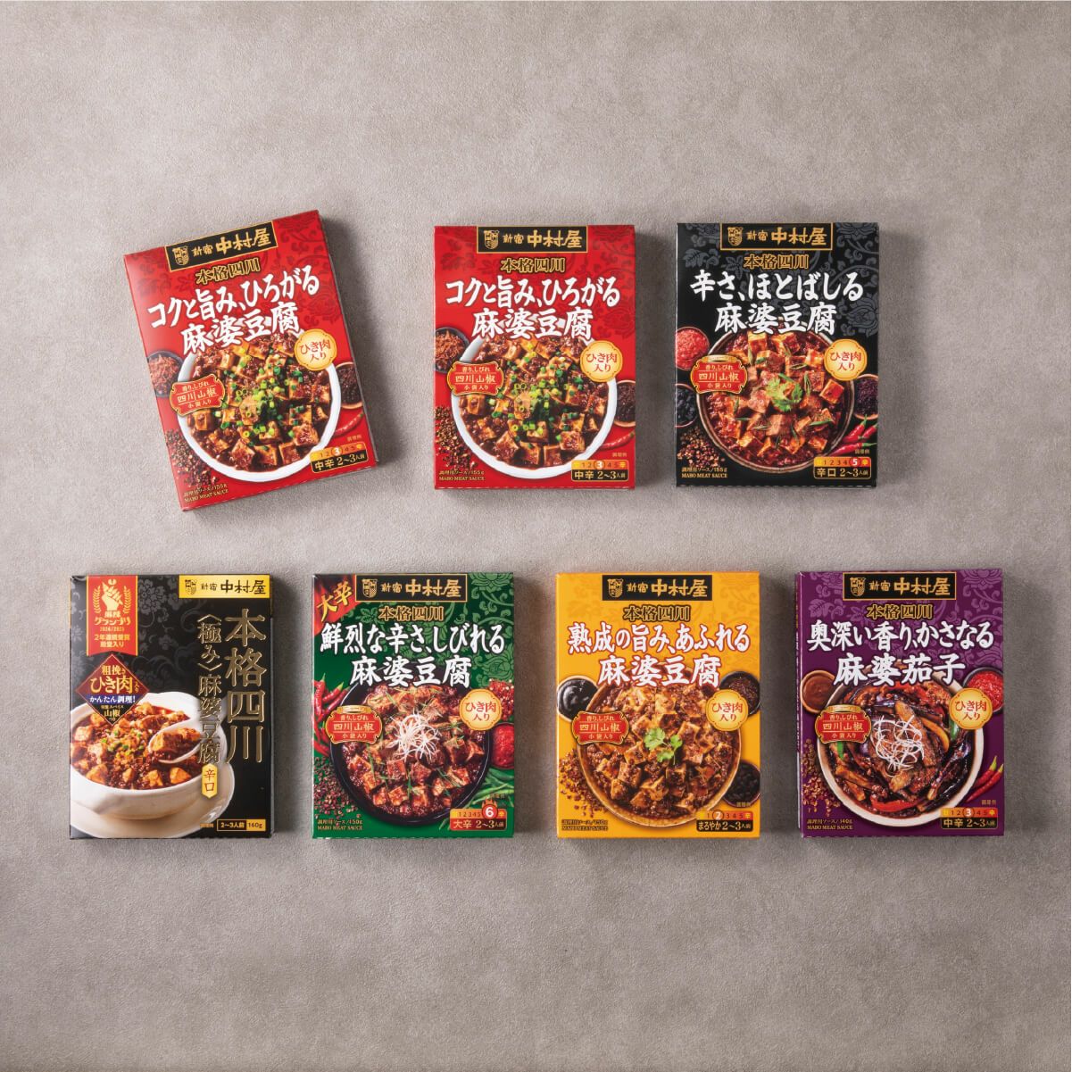 新宿中村屋　四川麻婆豆腐コンプリートBOX（赤）の詰め合わせ内容。中辛・辛口・激辛の麻婆豆腐の素と麻婆茄子の素が整然と並ぶ中身が見える画像