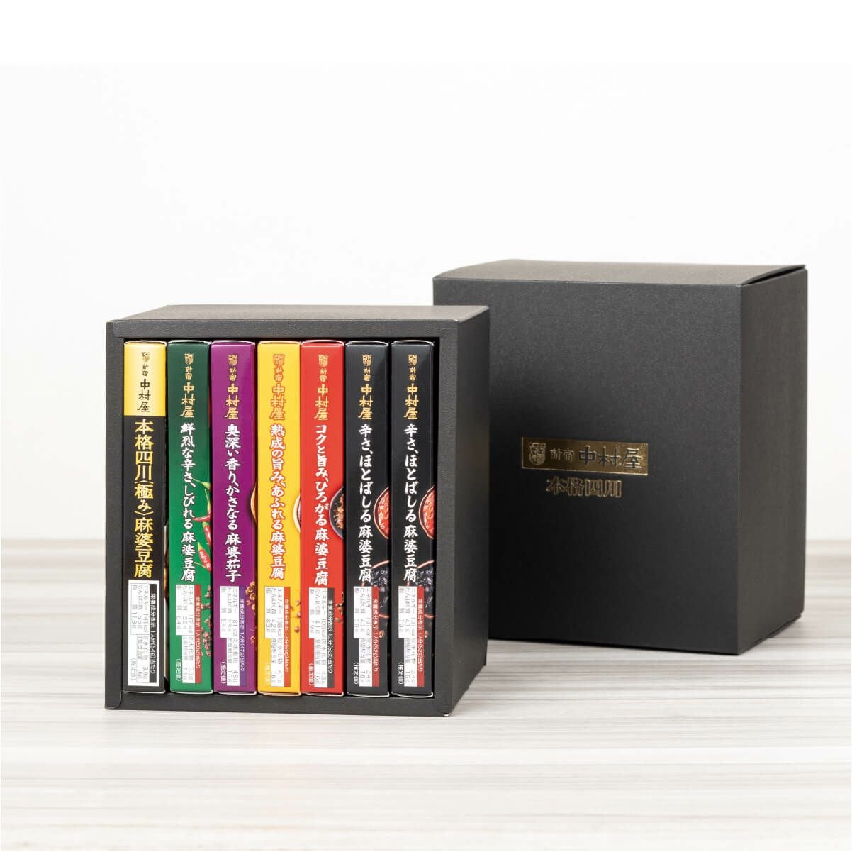 新宿中村屋　四川麻婆豆腐コンプリートBOX（黒）の蓋を開けた状態。麻婆豆腐や麻婆茄子などの中華ソースが詰め合わせられた内容が見える画像