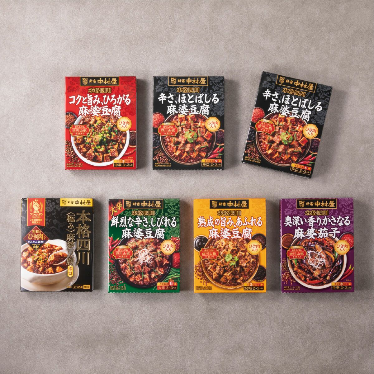 新宿中村屋　四川麻婆豆腐コンプリートBOX（黒）の詰め合わせ内容。中辛・辛口・激辛の麻婆豆腐の素と麻婆茄子の素が整然と並ぶ中身が見える画像